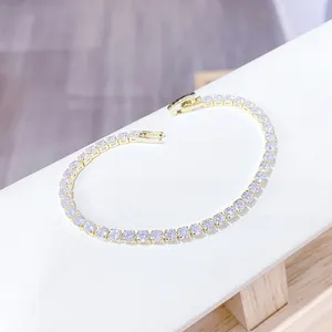 Primer plano detallado de una pulsera tenis bañada en oro con circonitas y cierre desplegable