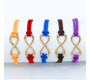 Detail of five infinity charm bracelets in assorted colors on a white display stand