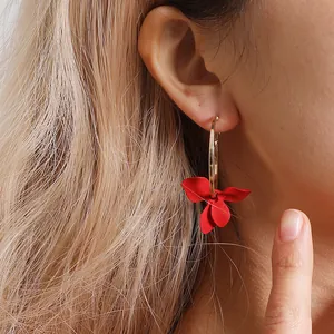 Boucles d'oreilles asymétriques avec grands anneaux dorés et pendentifs de fleurs rouges