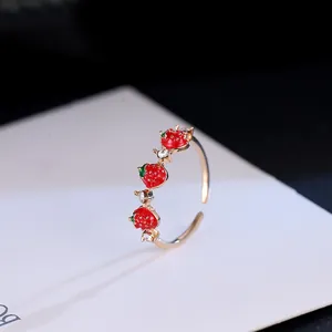 Adjustable gold plated ring with three red enamel strawberries and white crystals