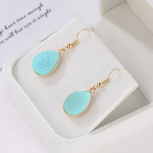 Elegant gold-tone teardrop hook earrings with light blue crystal cluster in a gift box