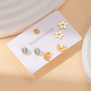Detail view of gold stainless steel stud earrings set with star and zircon designs