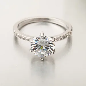 Gros plan d'une bague en zircone ronde avec serti à six griffes et accents brillants