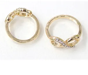Close-up of infinity symbol rings in gold finish with sparkling rhinestone inlay details