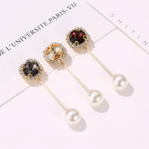 Detail of round crystal brooches with diamond halo and pearl caps on gold pins