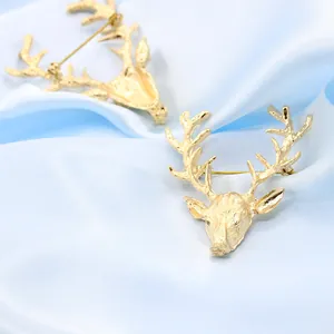 Paire d'élégantes broches tête de renne dorée sur tissu en soie bleu doux