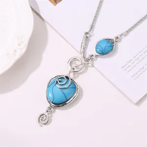 Bohemian vintage necklace with blue turquoise and intricate silver spiral charms on white