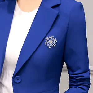 Broche flocon de neige élégante avec cristaux sur le revers d'un blazer bleu marine