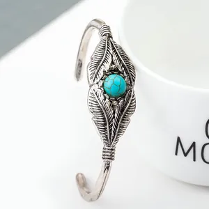 Dettaglio ravvicinato del bracciale vintage a piuma d'argento con pietra turchese