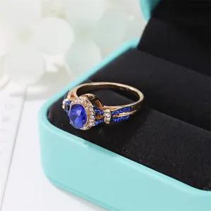 Elegant gold ring with oval blue zircon center stone and diamond accents in a gift box