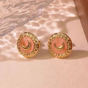 Detail of vintage gold-plated round studs with peach enamel and crescent moon motif