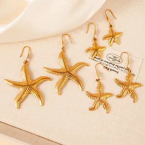 Three sizes of 18K gold plated stainless steel starfish earrings on beige silk fabric