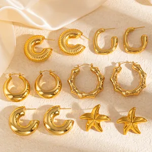 Set of five 18K gold plated geometric stainless steel hoop earrings on beige silk fabric