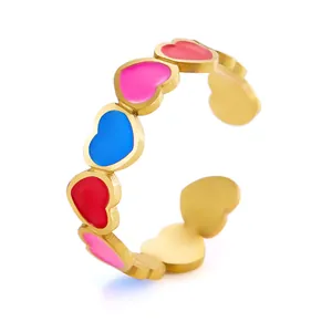 Detalle del anillo dorado ajustable con diseños de corazones coloridos en esmalte rojo y azul