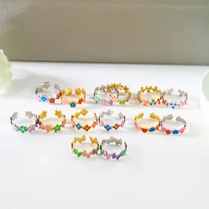 Detalle de anillos de esmalte de colores con flores y corazones y banda ajustable