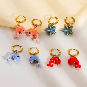 Gold stainless steel ocean series earrings featuring dolphin and starfish enamel pendants