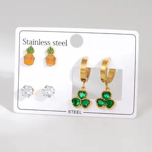 Detailed view of stainless steel earring set featuring clover drops and pineapple studs
