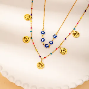 Detail of gold-plated necklaces with Tree of Life charms and Evil Eye pendants on a plate