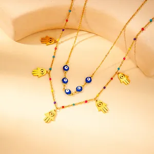 Detail of gold evil eye and Hamsa hand double-layer necklace with colorful beads