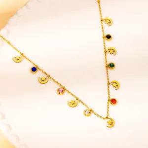 Detail of gold star and moon necklace with colorful zircon gemstones on ceramic plate