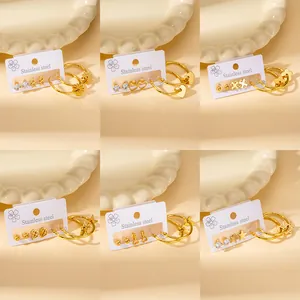 Detail view of various gold stainless steel stud earrings with flower and heart designs