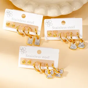 Detailed close-up of golden stainless steel earring set with heart and butterfly charms