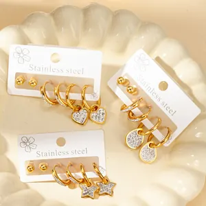 Detail of gold stainless steel earrings set with heart, star, and teardrop rhinestone charms