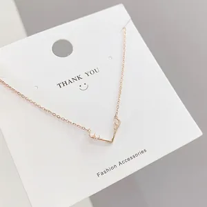 Close-up of rose gold elk antler pendant necklace on white display card with chain details