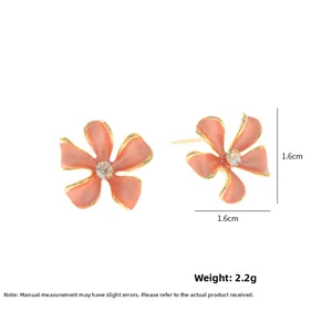 Detail van 1,6cm roze bloem oorknopjes met gouden randen en zirkonia centrum