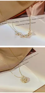 Dettaglio della collana a quadrifoglio dorata che si apre in quattro cuori uniti