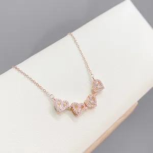 Dettaglio della collana quadrifoglio oro rosa con ciondoli a cuore e zirconi micro-pave