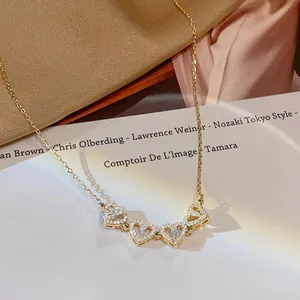 Collana a cuore quadrifoglio dorata con zirconi micro-pave su elegante tessuto di raso