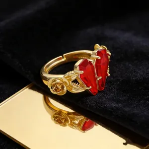 Detail view of dual red coffin stones and rose carvings on a gothic gold adjustable ring