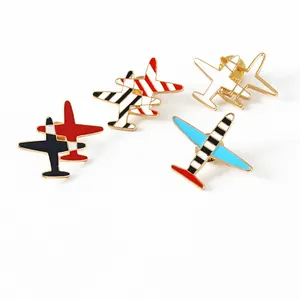 Set of four colorful airplane enamel pins with gold metal finish on white background