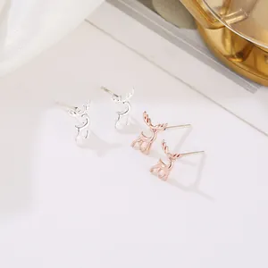 Dettaglio di orecchini a perno a cervo minimalisti in argento e oro rosa su seta