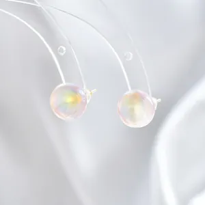 Macro-detail van iriserende zeemeermin pareloorbellen met goudlaag en S925 zilveren pins