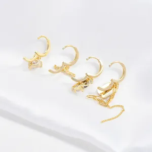 Set de cuatro pendientes dorados con colgantes de corazón, oso, letra y borlas de cadena