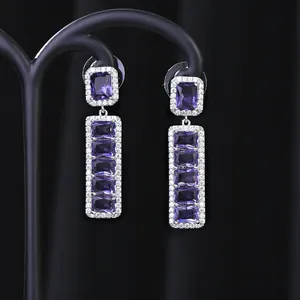 Dettaglio di orecchini pendenti con zirconi viola e cristalli micro-pavé su argento