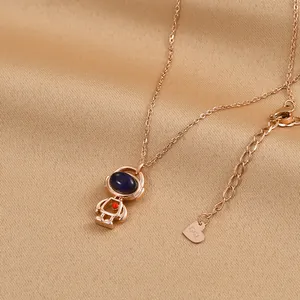 Collier astronaute en or rose avec casque en pierre bleue et petit pendentif cœur rouge