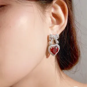 Dettaglio degli orecchini a farfalla in argento S925 con zircone rosso a cuore