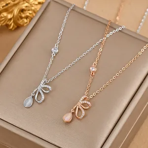 Detail of bow-shaped necklaces with cat's eye stone pendants in silver and rose gold