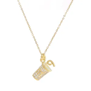 Elegant gold letter M drink cup pendant necklace with sparkling white zircons on white background
