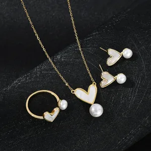 Dettaglio di un set di gioielli a cuore dorato con inserti in madreperla e perle