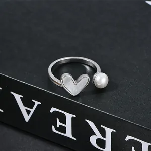 Dettaglio anello regolabile in argento con inserto a cuore e perla bianca rotonda