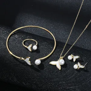 Detail of gold jewelry set featuring elegant fishtail mother of pearl and white pearls