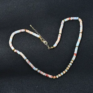 Détail macro d'un collier bohème avec perles en pierre naturelle et perles dorées