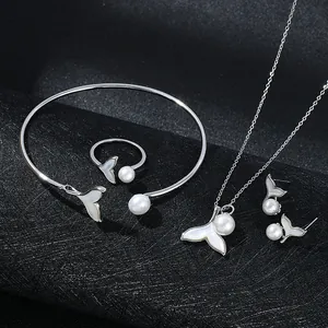 Elegant fishtail jewelry set with white shell inlay and pearls on a black background