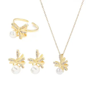 Elegante set di gioielli dorati con fiocchi, cristalli e perle bianche da donna