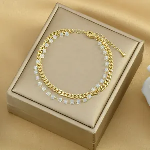Dettaglio del bracciale dorato a doppio strato con catena groumette e perline quadrate opache
