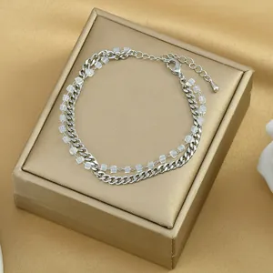 Dettaglio bracciale a doppio strato in argento con perline quadrate su raso dorato